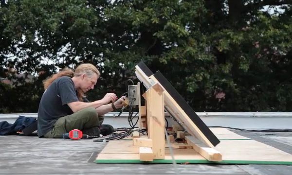 Gallery technician Neil Fowler installing solar panels on roof